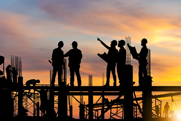 construction workers on a job site at sunset