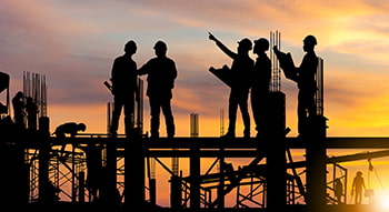 construction workers at a job site at sundown